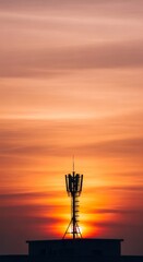 Obraz premium Silhouette of a telecommunication tower during sunset. Wireless communication and mobile network infrastructure for 4G 5G technology.