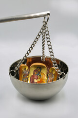 Religious icon symbols on metal balance scale closeup.