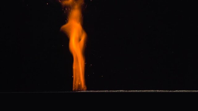 Burning Gunpowder on Black. A thin horizontal strip of gunpowder ignites at one end and gradually burns away against a black background