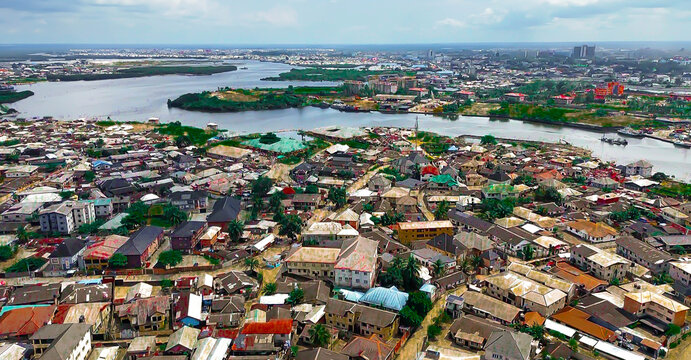Aerial view of Amadi Ama town blending into the delta, with waterways reflecting the sky and dense buildings dotting the landscape, Port Harcourt, Rivers State, Nigeria.