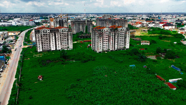 Aerial view of unfinished high-rise buildings standing stark against the lush green fields near Amadi Ama town, Port Harcourt, Rivers State, Nigeria.