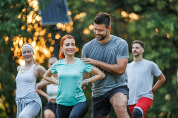 Group of people exercising outdoors in a park during sunset in warm weather