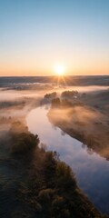 Obraz premium Sunrise over serene river with misty landscape and trees in early morning light