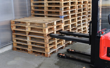 Electric pallet truck inserting forks into wooden pallets © Rodrigo Noceda