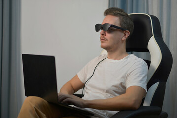 Man Using Wearable AR XR Smart Glasses While Using Laptop