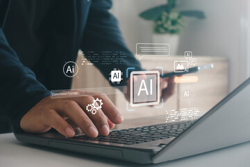 Man using laptop and smartphone with glowing AI interface icon, representing modern artificial intelligence technology, digital innovation, data processing and smart automation in everyday workflow.