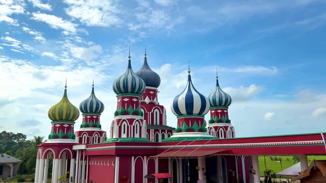 Besut, Terengganu, Malaysia - &lrm;November 27, 2025 - A vibrant Russian-style mosque with eight colorful onion domes under a bright blue sky in Besut, Terengganu.