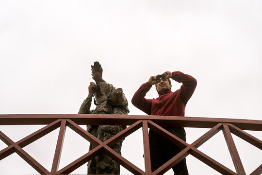People bird watching photographing wildlife at wetland