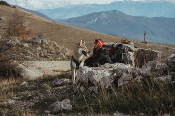 A hiker with a dog during an outdoor trekking excursion in the Abruzzo region of central Italy. The...