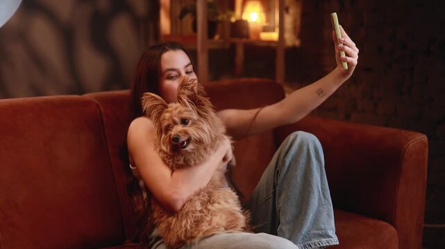 casual girl selfie, caucasian girl capturing selfie with fluffy dog, young woman enjoying relaxed moment with pet and smartphone, casual scene of woman taking playful selfie with her furry companion