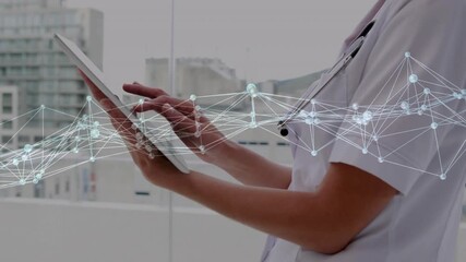 Clinician tapping, swiping, hovering tablet as network graphic appearing, reviewing patient data - Powered by Adobe
