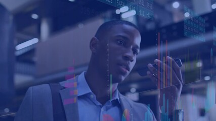 Man holding smartphone, speaking and monitoring animated financial charts shifting across office - Powered by Adobe