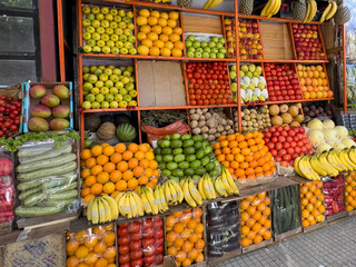 Colorful outdoor fruit stall with neatly stacked fresh produce display