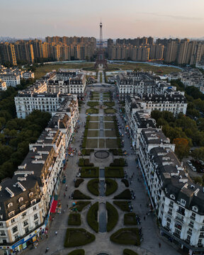 Aerial view of symmetrical gardens and European-style buildings stretching toward a distant tower under a soft sky, Hangzhou, Zhejiang, China.