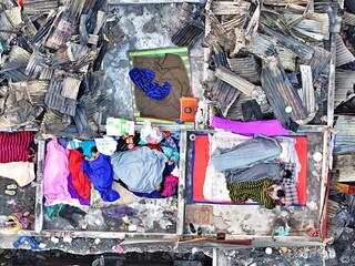 Dhaka, Bangladesh - 28 November 2025: Aerial view of the Korail slum reveals remnants of a devastating fire, with colorful clothes scattered amidst the charred debris.