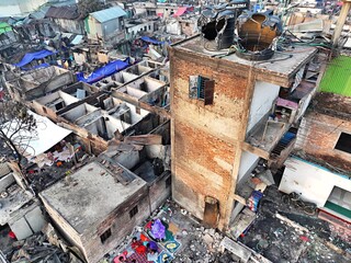 Dhaka, Bangladesh - 28 November 2025: Aerial view of the Korail slum reveals a tapestry of damaged and burnt structures, with signs of life amidst the devastation.