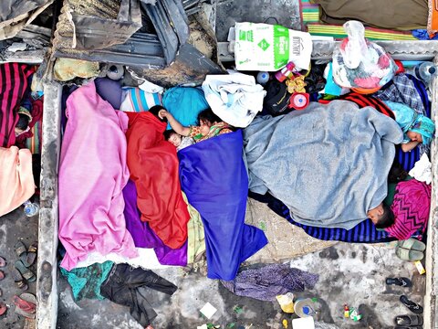 Dhaka, Bangladesh - 28 November 2025: Aerial view of vibrant blankets amidst the muted tones of a packed dwelling in the Korail slum, creating a striking contrast.