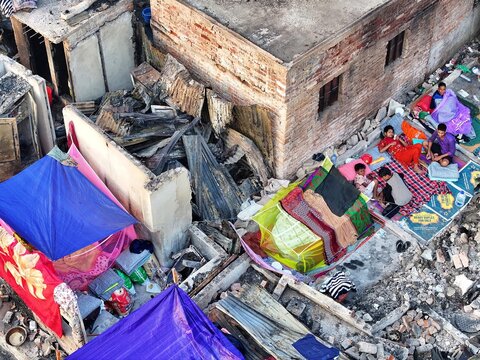 Dhaka, Bangladesh - 28 November 2025: Aerial view of the Korail slum, a landscape of makeshift shelters where life unfolds on rooftops under a relentless sun.