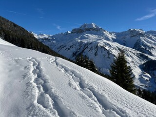 Wonderful winter hiking trails and traces in the fresh alpine snow cover of the Swiss Alps and over the village of St. Ant&ouml;nien - Canton of Grisons, Switzerland (Kanton Graub&uuml;nden, Schweiz)