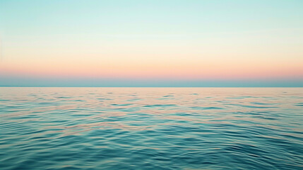 Obraz premium Calm ocean water reflecting the pastel colors of the sunset sky at dusk