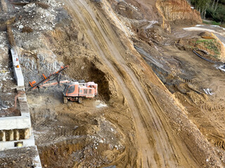 View of an earthmover on a construction site, leaving tracks on the bare ground, against a backdrop of raw soil and concrete structures, Istanbul, Istanbul, Turkey.