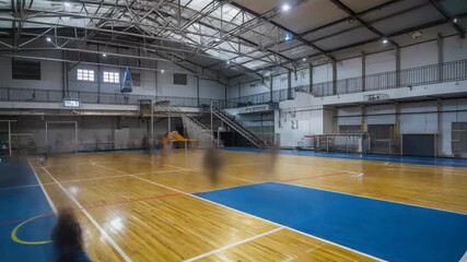 Empty indoor basketball court with polished wooden floor and blue sections, featuring high ceilings and upper viewing areas. - Powered by Adobe
