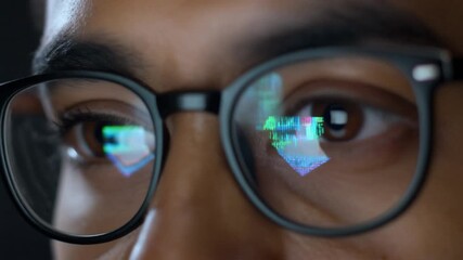 Focused professional analyzing digital data on a computer screen, with code and charts reflecting in their glasses in a dark office - Powered by Adobe