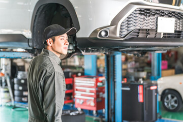 A middle-aged Asian man working as a mechanic, car mechanic, or mechanic at a repair shop