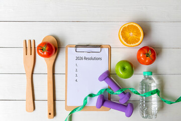2026 Resolutions.  New year for New Changes Healthy.  Fresh vegetable fruits and healthy food for sport equipment for women diet slimming weight loss on white wood.  Healthy and Holiday Concept