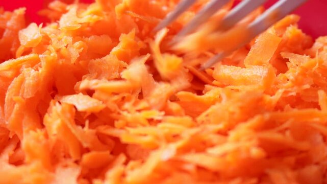 Close-up of a set of grated carrots with a fork