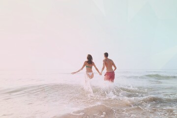 Happy couple running into the water