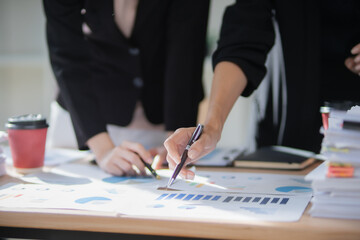 Smiling Asian businesswoman shaking hands with colleagues in office meeting, working together to...