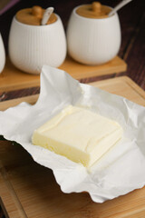 Fresh butter resting on parchment paper in a kitchen setting