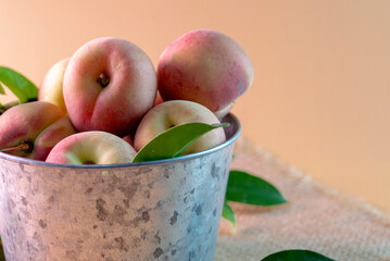 A metal bowl with fresh peaches 