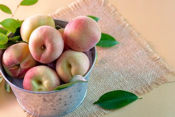 A metal bowl with fresh peaches 