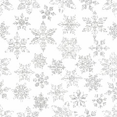 Elegant seamless pattern of intricate silver glitter snowflakes on a white background for winter holiday decoration