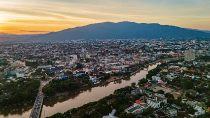 Obraz premium drone aerial sunset of Chiang Mai Thailand cityscape old town temples mountains and ping river, travel destination 