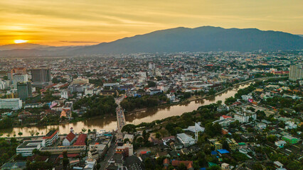Obraz premium drone aerial sunset of Chiang Mai Thailand cityscape old town temples mountains and ping river, travel destination 