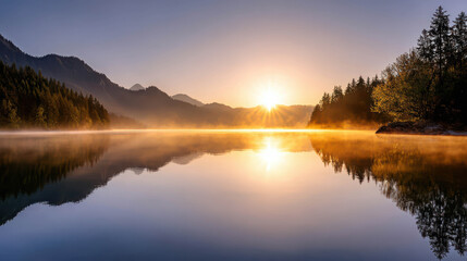Fototapeta premium Misty Sunrise Over Hidden Alpine Lake Surrounded by Mountains and Trees Reflecting Warm Colors on Calm Waters Near Scenic Hydro Landscape
