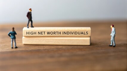Miniature Figures Representing High Net Worth Individuals on a Block with Text on a Wooden Surface