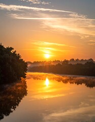 Sunrise casting warm glow over calm water reflecting the morning sky
