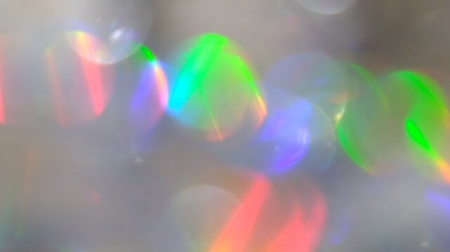Multicolored Glittering abstract flares bokeh background. Blurry abstract fairy light background with bokeh. Caustic light, refraction.