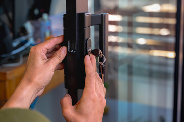 Close up locksmith installing handle door lock key on mirror door