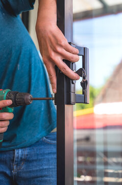 Close up locksmith installing door lock key on mirror door