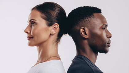 Studio portrait of diverse man and woman standing back to back, equality and unity concept