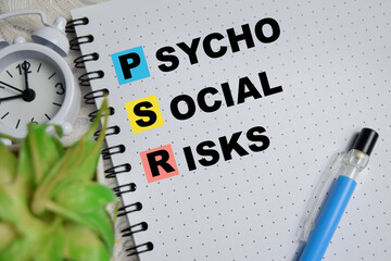 Concept of PSR - Psycho Social Risks write on book isolated on Wooden Table.