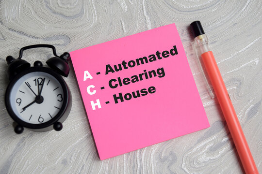 Concept of ACH - Automated Clearing House write on sticky notes isolated on Wooden Table.