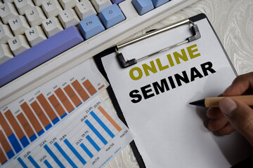 Concept of online seminar write on clipboard with financial graphs isolated on Wooden Table.