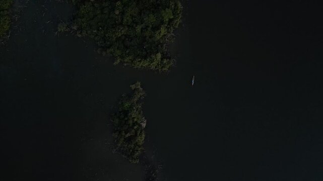Drone video of Lake Valencia at sunset, featuring smooth aerial views of golden reflections, tropical rainforest landscape, and serene Amazonian atmosphere in Madre de Dios, Peru