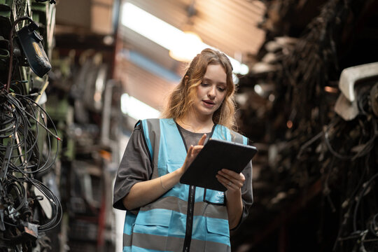 Portrait Caucasian woman engineer or mechanic use tablet computer checking auto part or car part at car part warehouse	